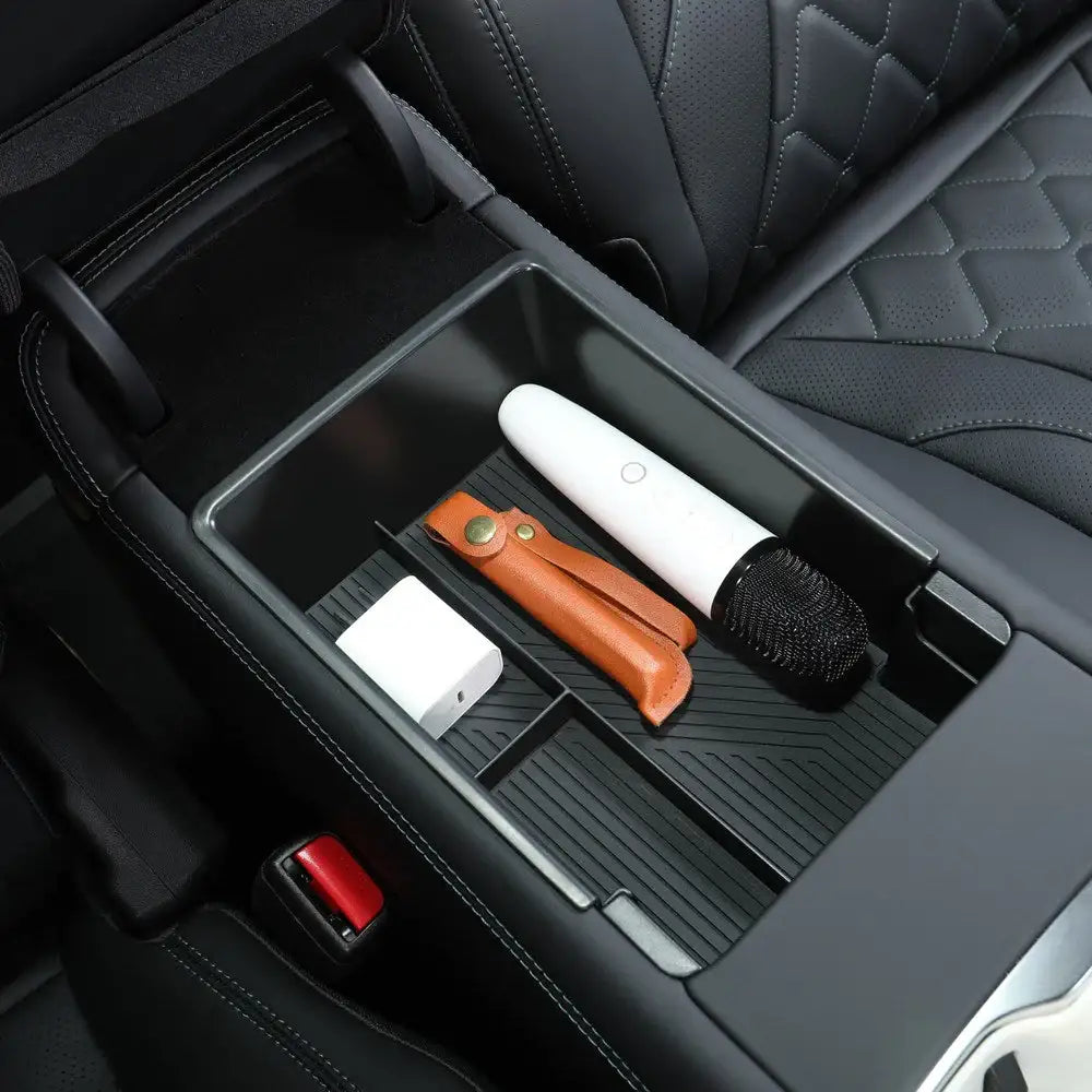 Car center console organizer with storage compartments, holding microphone, charger, and leather case