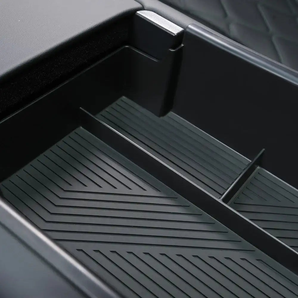 Black textured EV center console organizer tray with ribbed compartments for storage